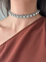 Gargantilla gris con strass XL y tiento de gamuza trenzado. Se cierra con cadena y ganchito para regular el largo.