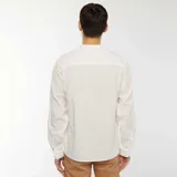 Camisa blanca de manga larga con cuello mao y textura gofrada.