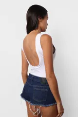 Body blanco al cuerpo de microfibra pesada, con escote cuadrado y espalda baja. Terminaciones en collareta. Para facilitar acceso, broches snap en entrepierna y elástico interno en contorno de tiro para mejor ajuste de la prenda al cuerpo.