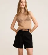 Short de jean azul de tiro alto, con bolsillos delanteros y traseros, trabillas y ruedo desflecado.