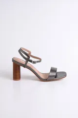 Sandalia de cuero color nude con pulsera al tobillo y taco cilíndrico de madera.
