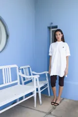 Camisa negra de algodón con cuello mao y mangas cortas. Presenta un pequeño bordado de una flor blanca en el pecho.