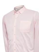 Camisa celeste de manga larga confeccionada en algodón pima y poliéster reciclado. Cuenta con cuello camisero, bolsillo en el pecho y calce regular.