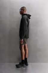Shorts de running negros confeccionados en tejido técnico ligero y elástico, con malla interior, cintura elástica ajustable con cordón, bolsillo trasero con cierre y perforaciones en las perneras.