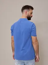 Remera polo celeste de piqué de algodón, corte clásico, con cuello y mangas acanalados.