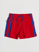 Short de baño azul con cintura elástica, rayas verdes en los laterales y bolsillo trasero con solapa roja y verde.