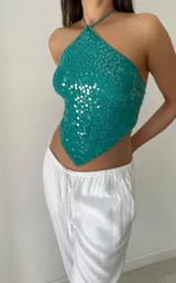 Top verde con lentejuelas, escote halter y espalda descubierta.