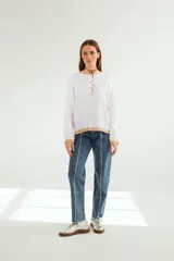Pantalón jean mom fit de tiro alto, color azul medio con costuras blancas a la vista.