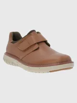 Zapato marrón de cuero con ajuste de velcro y suela gruesa color crema.