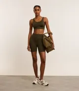 Conjunto deportivo color verde oliva, compuesto por un top deportivo con breteles anchos y calzas cortas tipo biker.
