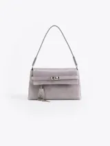 Cartera de cuero vacuno color gris, con acceso mediante torniquete metálico. Incluye un llavero colgante con candado y llave. Tiene un bolsillo interior con cierre y correa de cuero vacuno.