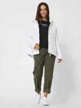 Campera puffer blanca con capucha, cierre frontal con cremallera, bolsillos laterales con cremallera y logo de la marca en la manga izquierda.