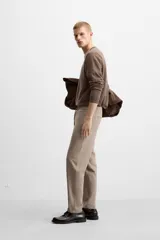 Pantalón color arena de corte recto, confeccionado en tejido elástico. Cuenta con cintura elástica ajustable con cordón, bolsillos laterales y bolsillos de vivo en la parte trasera.