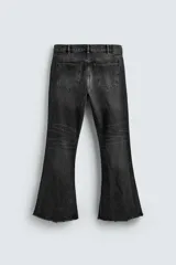 Pantalón de jean celeste, de tiro medio, corte ajustado en la parte superior y acampanado desde la rodilla. Tiene cinco bolsillos, efecto lavado y bajo irregular.