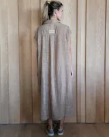 Túnica celeste de corte recto, con cuello camisero, mangas cortas, tajos laterales y cierre frontal con botones.