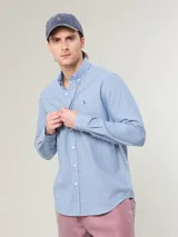 Camisa celeste a rayas verticales blancas, corte slim fit, con cuello abotonado y logo bordado en el pecho.