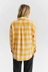 Camisa de franela color amarillo con patrón de cuadros, de corte recto y botones frontales.