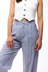 Pantalón de vestir a rayas verticales azules y blancas, de corte recto y tiro alto.