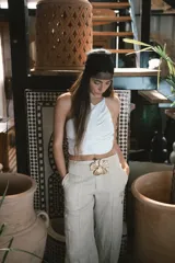 Pantalón de vestir negro de tiro alto, corte recto y pierna ancha. Presenta pliegues frontales y bolsillos laterales.