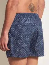 Bóxer de algodón blanco con estampado de flores pequeñas color celeste, con cintura elástica y logo de la marca en el centro.