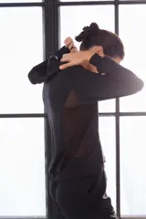 Campera deportiva negra con capucha y cierre frontal.