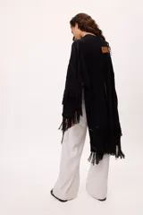 Ruana negra con flecos de algodón.