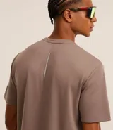 Remera deportiva marrón de corte clásico, confeccionada en tejido tech fleece con tecnología dry, cuello redondo y mangas cortas.