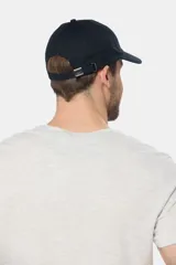 Gorra de béisbol azul marino confeccionada en lona de algodón, con visera curva y parche rectangular con logo en el frente.