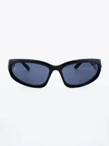 Lentes de sol negros con forma ovalada y patillas gruesas.