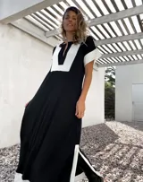 Vestido largo negro con paneles blancos en escote, mangas y ruedo.