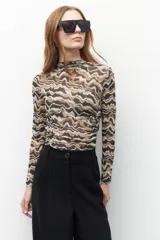 Top de manga larga en microtul estampado con diseño abstracto y semi-transparente.