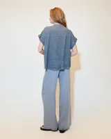 Remera celeste de lino y ramio, con corte boxy, manga japonesa, cuello mao, media cartera con broches metálicos y bolsillo plaqué con efecto de tapa.