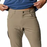 Pantalón de vestir negro, de corte recto, con bolsillos laterales y traseros. Se ajusta a la cintura con cinturón de cuero marrón.