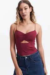 Top color borgoña con breteles finos, escote fruncido y abertura en el abdomen.