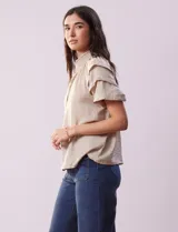 Blusa color beige de gasa con cuello fruncido, escote en V con lazo y mangas cortas con volados.