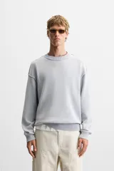 Sweater negro de algodón con cuello redondo y mangas largas. Tiene un acabado lavado con efecto desgastado y rib en cuello, puños y bajo.