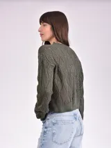 Sweater de punto calado color crudo, de corte holgado y mangas largas.