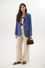 Blazer azul de lino con solapas de muesca, cierre frontal con botón y bolsillos con solapa.