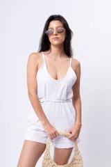 Mono corto blanco con breteles finos, escote en V y cinturón con hebilla circular.