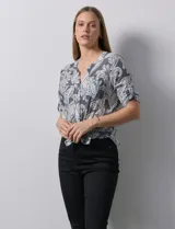 Blusa de gasa estampada color celeste con estampado paisley, marca Ruby Rd. Cuello a la base, escote en v y abertura con botones. Delantera con bolsillos. Largo de manga regulable con presilla y botón. Terminación de ruedo con nudo.