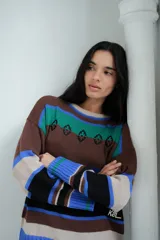 Buzo tejido con diseño de rayas horizontales en tonos marrón, azul, verde y blanco.