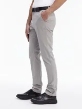 Pantalón chino slim fit color gris claro, con cinturón negro con hebilla metálica. Confeccionado con algodón orgánico.