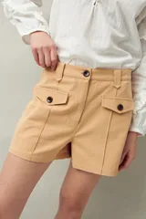 Short blanco de tiro alto con bolsillos delanteros con solapa y botones a la vista.