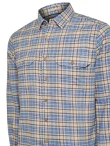 Camisa de franela a cuadros azul, beige y gris, de manga larga, con cuello camisero, cierre frontal con botones de madera, dos bolsillos con botón en el pecho y calce regular.