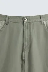 Pantalón de jean color verde con diseño de bloques de color en diferentes tonos de verde, corte amplio, tiro alto, cinco bolsillos y presilla para herramientas en la pierna.