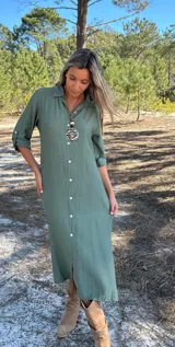 Vestido camisero verde militar de corte recto, largo midi, con cuello camisero, mangas 3/4 con trabilla y botón, cierre frontal con botones y tajos laterales.