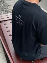 Remera negra oversize con cuello redondo y estampado pequeño en el pecho.