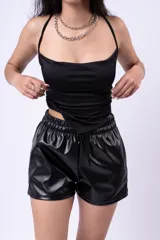 Top blanco de tirantes finos con diseño tipo pañuelo o bandana en la parte inferior, corte ajustado.