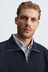 Sudadera azul marino de cuello alto con cierre frontal de cremallera, corte relaxed fit, manga larga y terminaciones en rib.