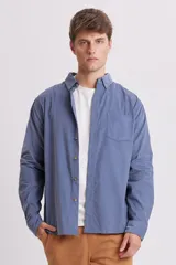 Camisa de micropana azul, de corte clásico con botones y bolsillo en el pecho.